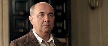 Movie still from “The Chorus” (2004), directed by Christophe Barratier – An older man wearing a brown jacket and a brown tie; Close Up shot, Low angle