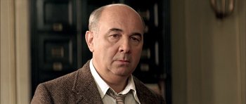 Movie still from “The Chorus” (2004), directed by Christophe Barratier – An older man wearing a jacket and a tie; Close Up shot, Low angle