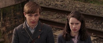 Movie still from “The Chronicles of Narnia: The Lion, the Witch and the Wardrobe” (2005), directed by Andrew Adamson – A boy and a girl standing next to each other on train tracks; Close Up shot, High angle