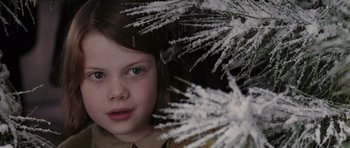 Movie still from “The Chronicles of Narnia: The Lion, the Witch and the Wardrobe” (2005), directed by Andrew Adamson – A young girl is standing in front of a tree; Close Up shot, Over the shoulder angle