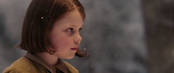 Movie still from “The Chronicles of Narnia: The Lion, the Witch and the Wardrobe” (2005), directed by Andrew Adamson – A young girl is looking to her left; Close Up shot, Over the shoulder angle