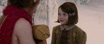 Movie still from “The Chronicles of Narnia: The Lion, the Witch and the Wardrobe” (2005), directed by Andrew Adamson – A young girl holding a present in her hands; Medium shot, Over the shoulder angle