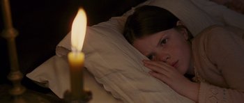 Movie still from “The Chronicles of Narnia: The Lion, the Witch and the Wardrobe” (2005), directed by Andrew Adamson – A young girl laying in a bed with a lit candle; Close Up shot, High angle