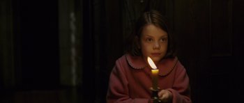 Movie still from “The Chronicles of Narnia: The Lion, the Witch and the Wardrobe” (2005), directed by Andrew Adamson – A young girl is holding a lit candle in the dark; Medium shot, High angle