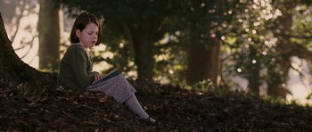 Movie still from “The Chronicles of Narnia: The Lion, the Witch and the Wardrobe” (2005), directed by Andrew Adamson – A girl sitting on the ground reading a book; Medium shot, High angle
