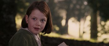 Movie still from “The Chronicles of Narnia: The Lion, the Witch and the Wardrobe” (2005), directed by Andrew Adamson – A young girl is holding a book in her hands; Close Up shot, Over the shoulder angle