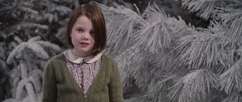 Movie still from “The Chronicles of Narnia: The Lion, the Witch and the Wardrobe” (2005), directed by Andrew Adamson – A little girl wearing a green sweater standing in front of a tree; Medium shot, Over the shoulder angle