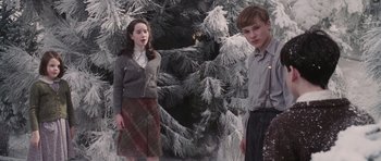 Movie still from “The Chronicles of Narnia: The Lion, the Witch and the Wardrobe” (2005), directed by Andrew Adamson – Two young people standing in front of a christmas tree; Medium shot, Low angle