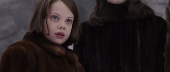 Movie still from “The Chronicles of Narnia: The Lion, the Witch and the Wardrobe” (2005), directed by Andrew Adamson – A young girl in a brown coat and a younger girl in a brown coat; Close Up shot, Over the shoulder angle