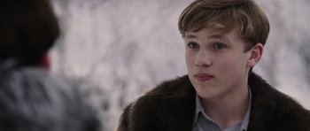 Movie still from “The Chronicles of Narnia: The Lion, the Witch and the Wardrobe” (2005), directed by Andrew Adamson – A young man wearing a fur coat looking into the distance; Close Up shot, Over the shoulder angle