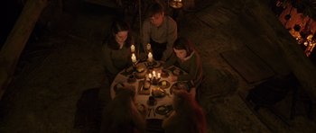 Movie still from “The Chronicles of Narnia: The Lion, the Witch and the Wardrobe” (2005), directed by Andrew Adamson – A group of people sitting around a dinner table with lit candles; Medium shot, High angle
