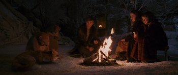 Movie still from “The Chronicles of Narnia: The Lion, the Witch and the Wardrobe” (2005), directed by Andrew Adamson – A man sitting in front of a fire in the snow; Wide shot, High angle