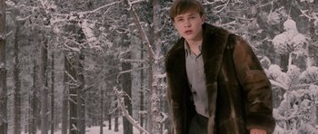 Movie still from “The Chronicles of Narnia: The Lion, the Witch and the Wardrobe” (2005), directed by Andrew Adamson – A man in a fur coat standing next to a tree; Medium shot, Low angle