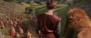 Movie still from “The Chronicles of Narnia: The Lion, the Witch and the Wardrobe” (2005), directed by Andrew Adamson – A man in a red and black shirt is looking at a crowd of people; Wide shot, High angle