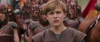 Movie still from “The Chronicles of Narnia: The Lion, the Witch and the Wardrobe” (2005), directed by Andrew Adamson – A young boy in a brown shirt and a group of people; Close Up shot, Low angle