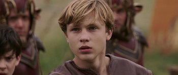 Movie still from “The Chronicles of Narnia: The Lion, the Witch and the Wardrobe” (2005), directed by Andrew Adamson – A young boy with blonde hair and blue eyes looking at the camera; Close Up shot, Low angle