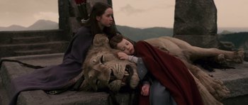 Movie still from “The Chronicles of Narnia: The Lion, the Witch and the Wardrobe” (2005), directed by Andrew Adamson – Two girls and a boy sleeping next to a lion; Wide shot, High angle