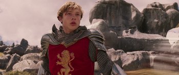 Movie still from “The Chronicles of Narnia: The Lion, the Witch and the Wardrobe” (2005), directed by Andrew Adamson – A young man dressed as a medieval knight in front of a rock formation; Medium shot, Low angle