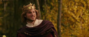 Movie still from “The Chronicles of Narnia: The Lion, the Witch and the Wardrobe” (2005), directed by Andrew Adamson – A man wearing a gold crown and a maroon robe; Close Up shot, Over the shoulder angle