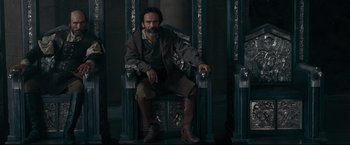 Movie still from “The Chronicles of Narnia: Prince Caspian” (2008), directed by Andrew Adamson – A man sitting on a throne in a room; Medium shot, High angle
