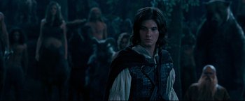 Movie still from “The Chronicles of Narnia: Prince Caspian” (2008), directed by Andrew Adamson – A young man in medieval garb stands in front of a group of people; Medium shot, Over the shoulder angle