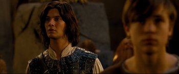 Movie still from “The Chronicles of Narnia: Prince Caspian” (2008), directed by Andrew Adamson – A young man wearing a leather vest and standing next to another young man; Close Up shot, Over the shoulder angle