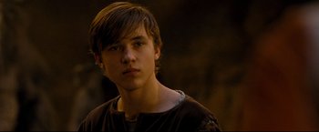 Movie still from “The Chronicles of Narnia: Prince Caspian” (2008), directed by Andrew Adamson – A young man with long brown hair wearing a brown t - shirt; Close Up shot, Over the shoulder angle