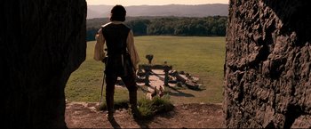Movie still from “The Chronicles of Narnia: Prince Caspian” (2008), directed by Andrew Adamson – A man standing on top of a grass covered field; Wide shot, High angle