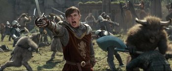 Movie still from “The Chronicles of Narnia: Prince Caspian” (2008), directed by Andrew Adamson – A man in a red and brown outfit is yelling at a group of people; Medium shot, Low angle