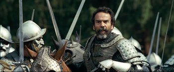 Movie still from “The Chronicles of Narnia: Prince Caspian” (2008), directed by Andrew Adamson – A man with a beard wearing armor and holding a sword; Close Up shot, Over the shoulder angle
