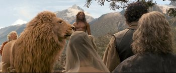 Movie still from “The Chronicles of Narnia: Prince Caspian” (2008), directed by Andrew Adamson – A man with a beard is standing next to a lion; Medium shot, Over the shoulder angle