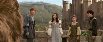 Movie still from “The Chronicles of Narnia: Prince Caspian” (2008), directed by Andrew Adamson – A group of people standing next to each other near a castle; Medium shot, Low angle