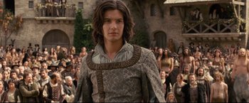 Movie still from “The Chronicles of Narnia: Prince Caspian” (2008), directed by Andrew Adamson – A young man in medieval garb standing in front of a crowd; Medium shot, Over the shoulder angle