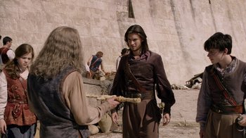 Movie still from “The Chronicles of Narnia: The Voyage of the Dawn Treader” (2010), directed by Michael Apted – A man in a brown shirt is holding a stick; Medium shot, Over the shoulder angle