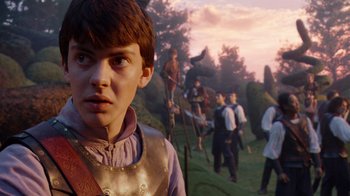 Movie still from “The Chronicles of Narnia: The Voyage of the Dawn Treader” (2010), directed by Michael Apted – An image of a young boy in front of some people; Medium shot, Low angle
