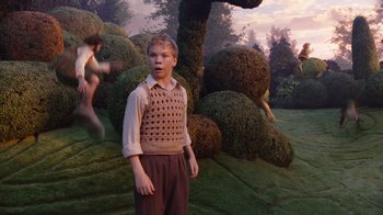 Movie still from “The Chronicles of Narnia: The Voyage of the Dawn Treader” (2010), directed by Michael Apted – A young boy standing in front of bushes; Wide shot, Over the shoulder angle