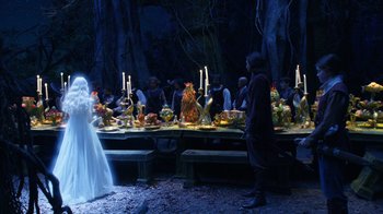 Movie still from “The Chronicles of Narnia: The Voyage of the Dawn Treader” (2010), directed by Michael Apted – A group of people sitting at a table with food on top of it; Wide shot, Over the shoulder angle