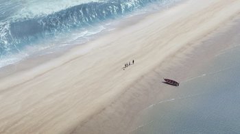 Movie still from “The Chronicles of Narnia: The Voyage of the Dawn Treader” (2010), directed by Michael Apted – A group of people standing on a beach next to the ocean; Extreme Wide shot, Overhead angle
