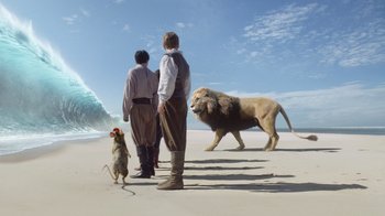Movie still from “The Chronicles of Narnia: The Voyage of the Dawn Treader” (2010), directed by Michael Apted – Two men stand on the beach with a dog and a lion; Wide shot, Low angle