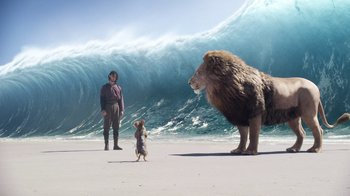 Movie still from “The Chronicles of Narnia: The Voyage of the Dawn Treader” (2010), directed by Michael Apted – A man and a dog on the beach with a giant lion; Wide shot, Low angle