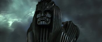 Movie still from “The Chronicles of Riddick” (2004), directed by David Twohy – A statue of a man with long hair and a mask; Close Up shot, Low angle