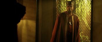 Movie still from “The Chronicles of Riddick” (2004), directed by David Twohy – A man wearing a red robe and a crown; Medium shot, Low angle