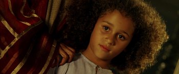 Movie still from “The Chronicles of Riddick” (2004), directed by David Twohy – A young girl is holding a pair of scissors in her hand; Close Up shot, High angle