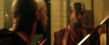 Movie still from “The Chronicles of Riddick” (2004), directed by David Twohy – A man wearing a hat looking at himself in the mirror; Close Up shot, Low angle