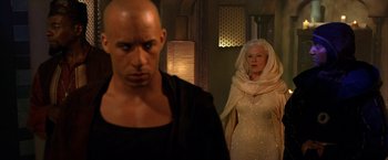 Movie still from “The Chronicles of Riddick” (2004), directed by David Twohy – A man and a woman standing next to each other in a room; Medium shot, Over the shoulder angle