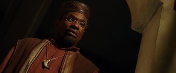 Movie still from “The Chronicles of Riddick” (2004), directed by David Twohy – A person wearing a hat and glasses; Close Up shot, Low angle