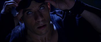 Movie still from “The Chronicles of Riddick” (2004), directed by David Twohy – A man's face in the dark; Close Up shot, High angle