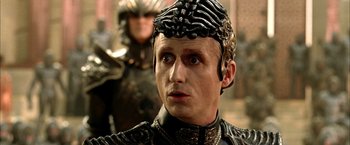 Movie still from “The Chronicles of Riddick” (2004), directed by David Twohy – A person wearing a helmet; Close Up shot, Over the shoulder angle