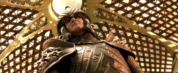 Movie still from “The Chronicles of Riddick” (2004), directed by David Twohy – A person wearing armor and a helmet; Close Up shot, Low angle