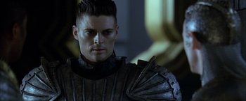 Movie still from “The Chronicles of Riddick” (2004), directed by David Twohy – A person wearing a suit of armor; Close Up shot, Over the shoulder angle